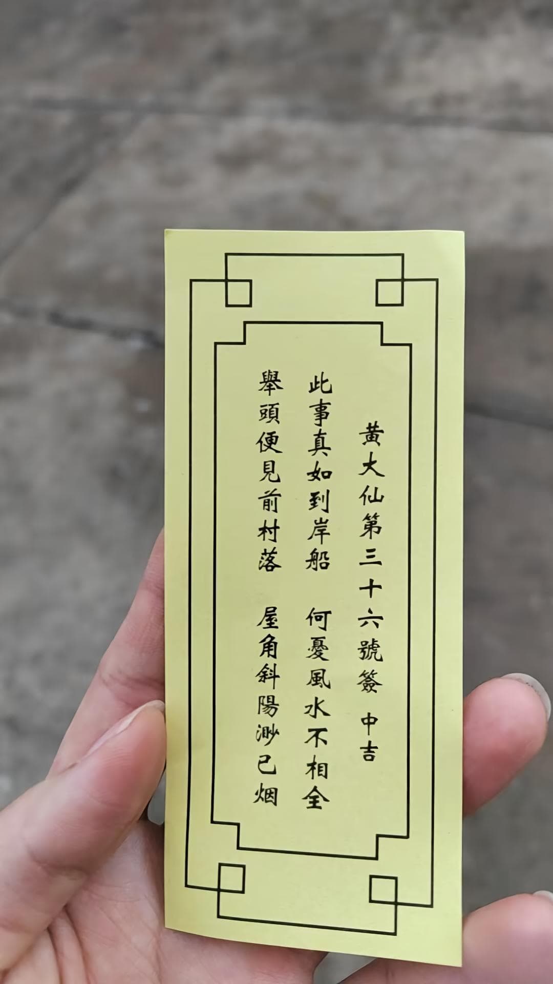 手持黃大仙第三十六號籤實物，籤上印有中吉及此事真如到岸船等四句籤詩
